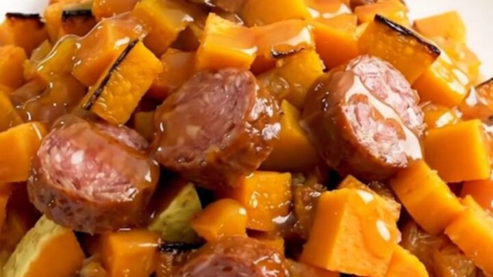 A finished slow cooker smoked sausage and butternut squash bake served on a white plate.