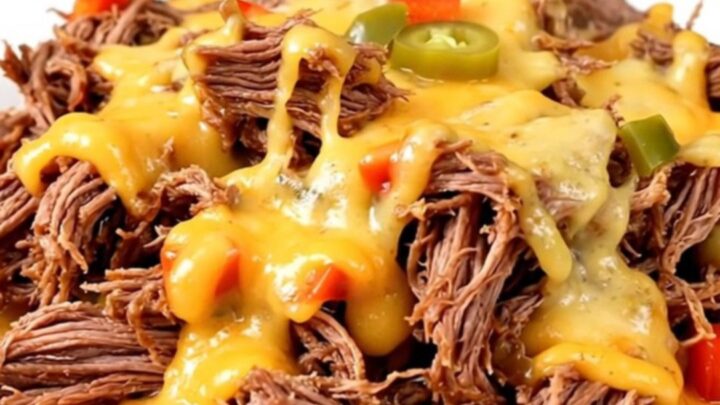 A plate of tender, slow-cooked shredded beef topped with melted pepper jack cheese.