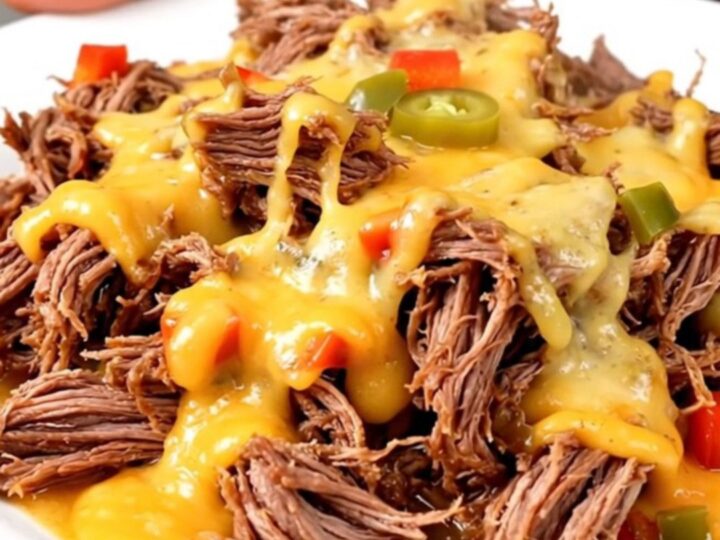 A plate of tender, slow-cooked shredded beef topped with melted pepper jack cheese.
