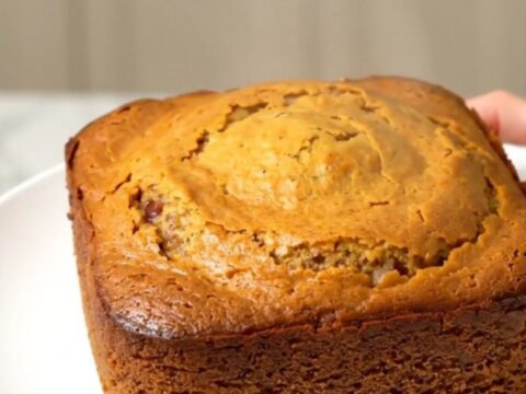 A warm, steaming pumpkin white chocolate dump cake in a slow cooker, featuring a golden, buttery crust.