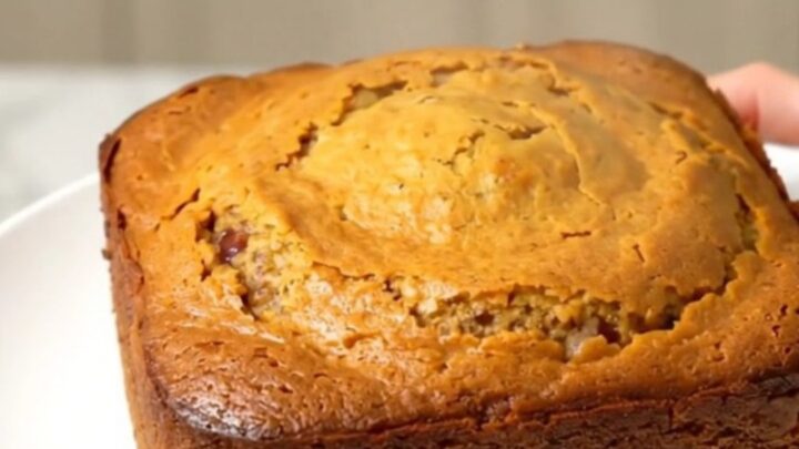 A warm, steaming pumpkin white chocolate dump cake in a slow cooker, featuring a golden, buttery crust.