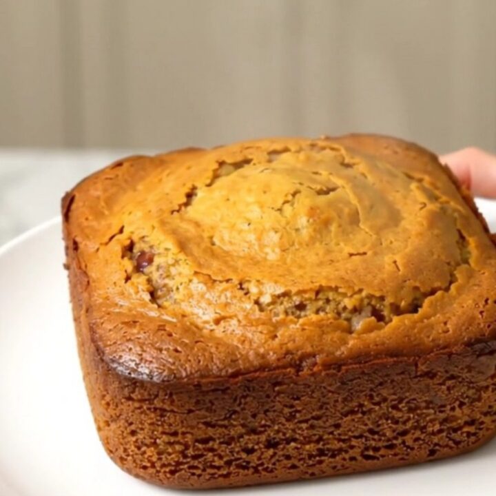 A warm, steaming pumpkin white chocolate dump cake in a slow cooker, featuring a golden, buttery crust.