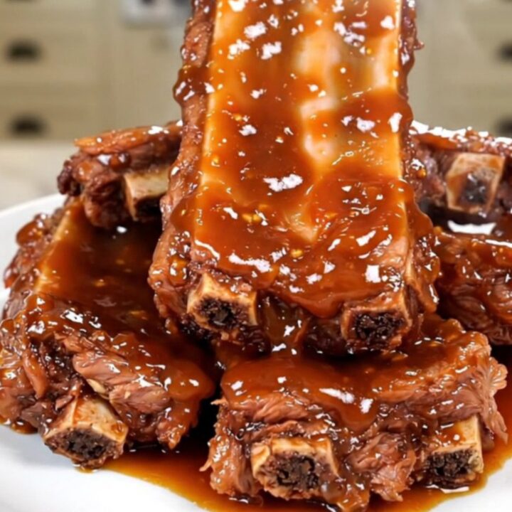 A top-down view of glossy sweet chili country-style ribs served on a white plate.