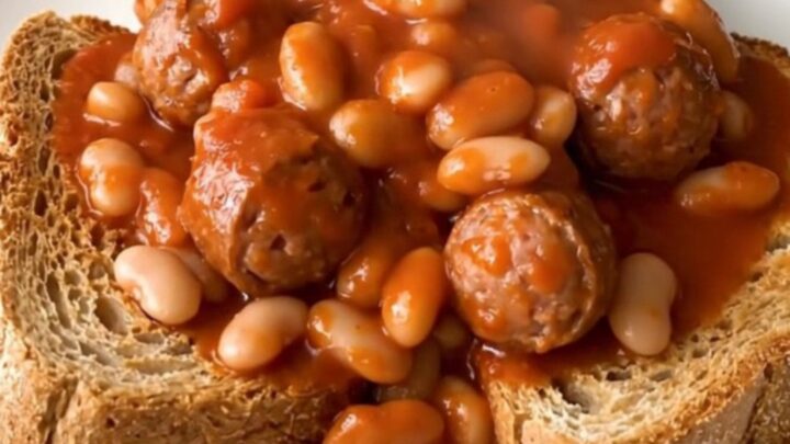 A rustic crockpot filled with steaming Italian sausage, white beans, and crushed tomatoes.