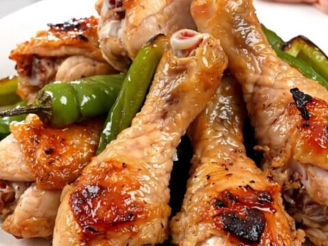 Close up of tender chicken drumsticks cooked in a slow cooker with colorful bell peppers and a zesty salsa sauce.