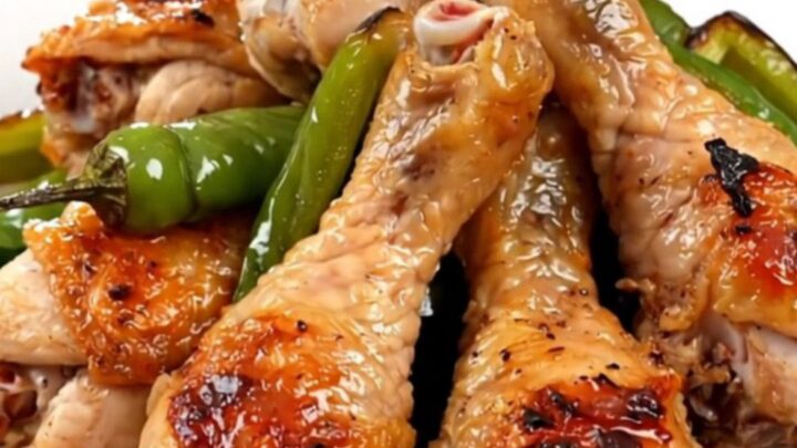 Close up of tender chicken drumsticks cooked in a slow cooker with colorful bell peppers and a zesty salsa sauce.