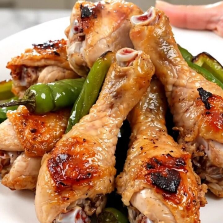 Close up of tender chicken drumsticks cooked in a slow cooker with colorful bell peppers and a zesty salsa sauce.