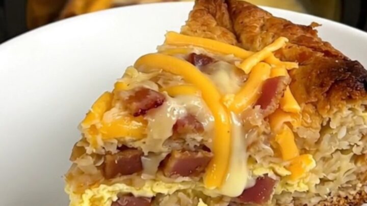 A warm, steaming slice of bacon and cheddar breakfast casserole on a white plate.
