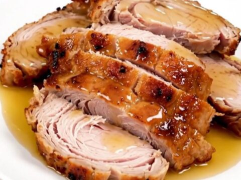 A slow cooker filled with raw turkey tenderloins, honey, and mustard before cooking.