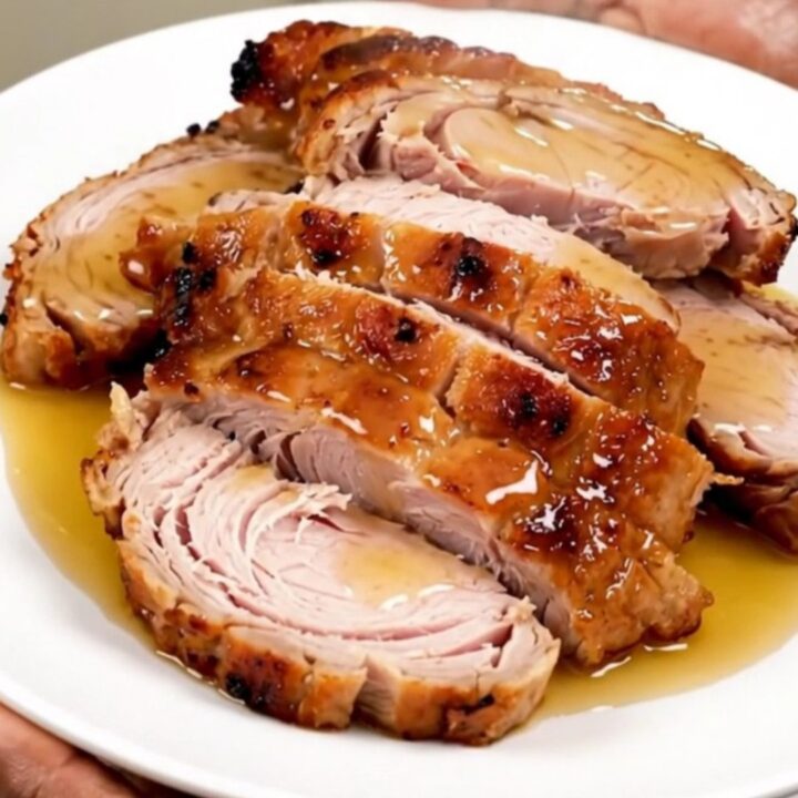 A slow cooker filled with raw turkey tenderloins, honey, and mustard before cooking.