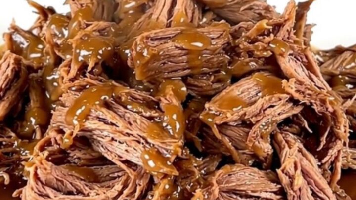 A close-up of tender, shredded maple bacon chuck roast served on a white plate.
