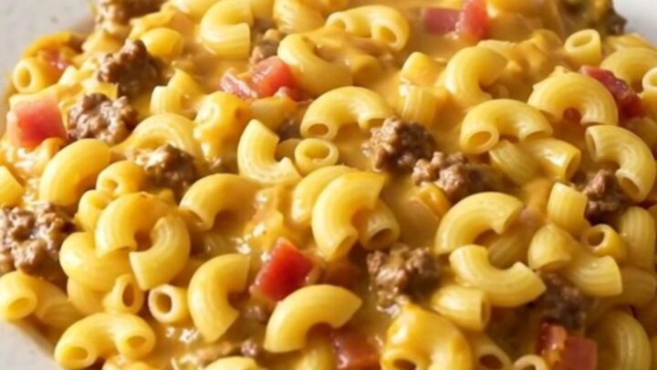 A steaming, glossy portion of slow cooker bacon cheeseburger macaroni casserole served on a white plate.