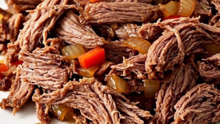 A top-down view of a black slow cooker filled with raw flank steak, sliced peppers, onions, and salsa.