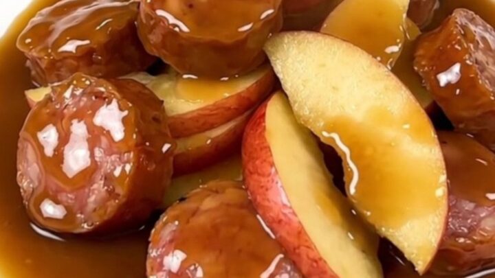 A close-up of finished maple Dijon smoked sausage and tender apple slices served on a white plate.
