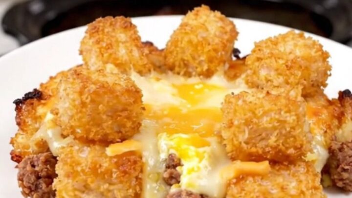 A hearty breakfast casserole in a slow cooker filled with golden tater tots, sausage, melted cheese, and eggs.