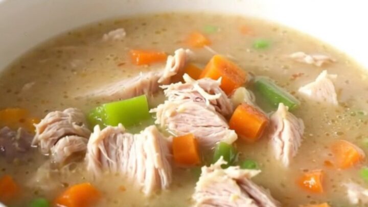 A bowl of creamy turkey pot pie soup with visible chunks of turkey, vegetables, and potatoes.
