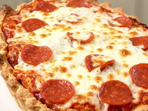 A close-up of a steaming pizza meatball casserole with melted mozzarella and pepperoni in a slow cooker.