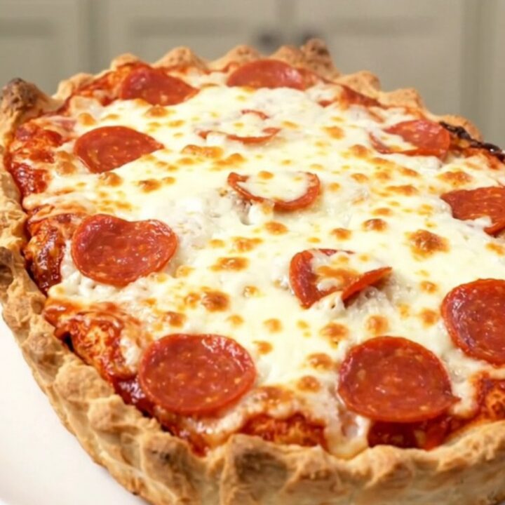 A close-up of a steaming pizza meatball casserole with melted mozzarella and pepperoni in a slow cooker.