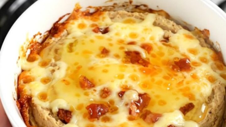 A close-up of the warm honey jalapeno bacon dip in a white bowl with a golden glossy finish.