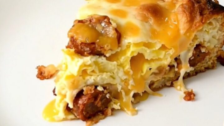 A steaming, golden-brown breakfast casserole with visible layers of chorizo, melted cheese, and hash browns in a slow cooker.
