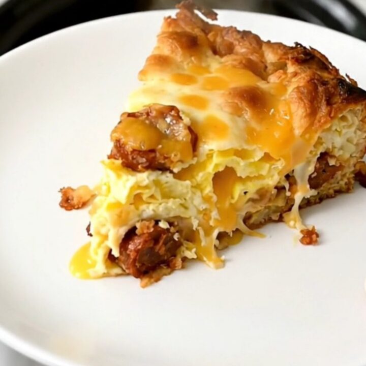 A steaming, golden-brown breakfast casserole with visible layers of chorizo, melted cheese, and hash browns in a slow cooker.