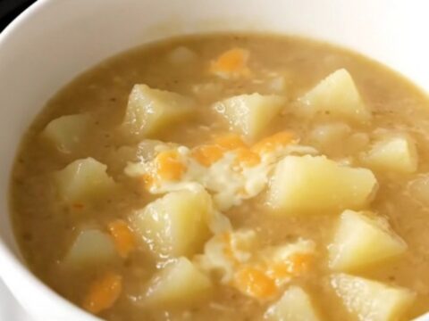 A close-up view of a bowl filled with creamy, steaming potato chowder.