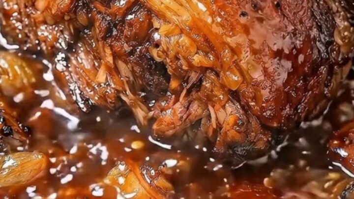 Tender shredded beef coated in glistening garlic butter gravy served in a slow cooker insert.