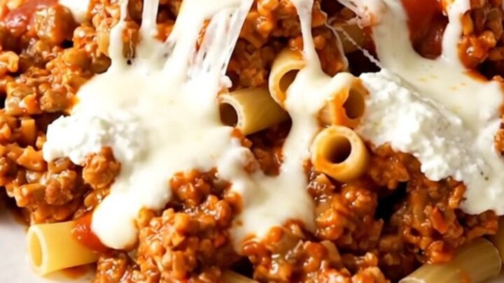 A steaming dish of beef ziti casserole served in a white bowl.