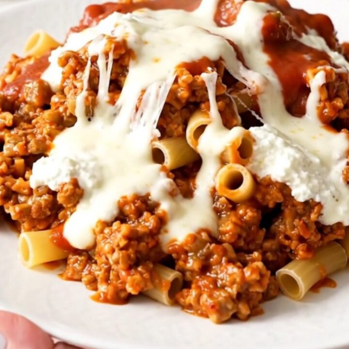 A steaming dish of beef ziti casserole served in a white bowl.
