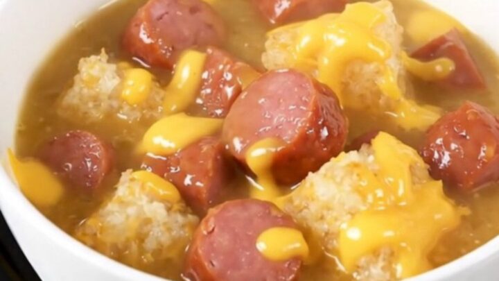 A white ceramic bowl filled with creamy kielbasa and hash brown chowder on a kitchen counter.