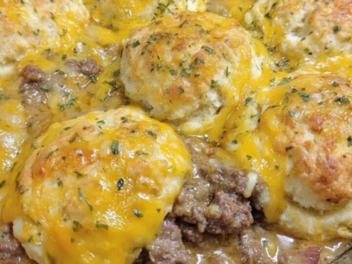 A golden-brown Cheddar Bay Hamburger Casserole bubbling in a cast-iron skillet with melted cheddar cheese stretching