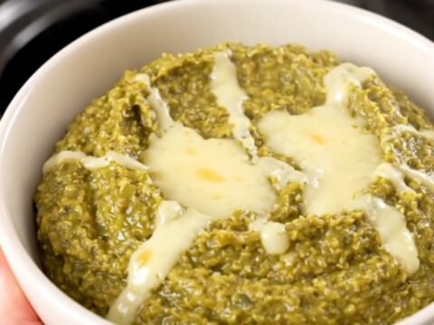 A warm, creamy Hatch green chile dip in a white bowl, steaming and glossy.
