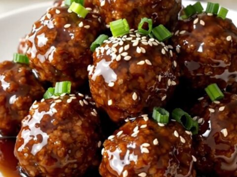 A top-down view of frozen turkey meatballs, pineapple, and teriyaki sauce in a slow cooker.