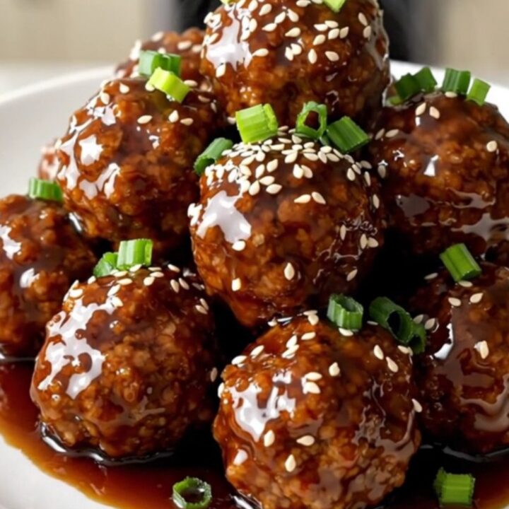 A top-down view of frozen turkey meatballs, pineapple, and teriyaki sauce in a slow cooker.