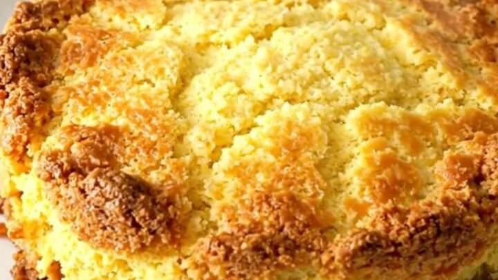 A hearty beef and cornbread casserole in a black slow cooker with a golden crust.
