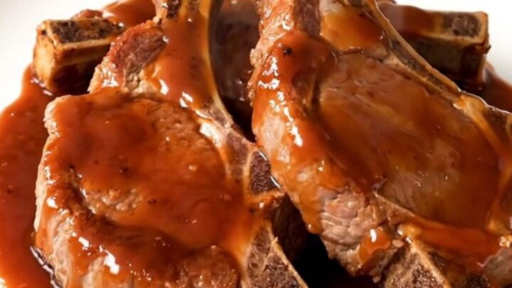 A top-down view of raw pork chops in a slow cooker with soy sauce, garlic, and sweet chili sauce being added.