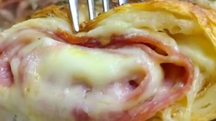 A warm, sliced homemade Italian stromboli on a wooden board, showcasing layers of meats and melted cheese.