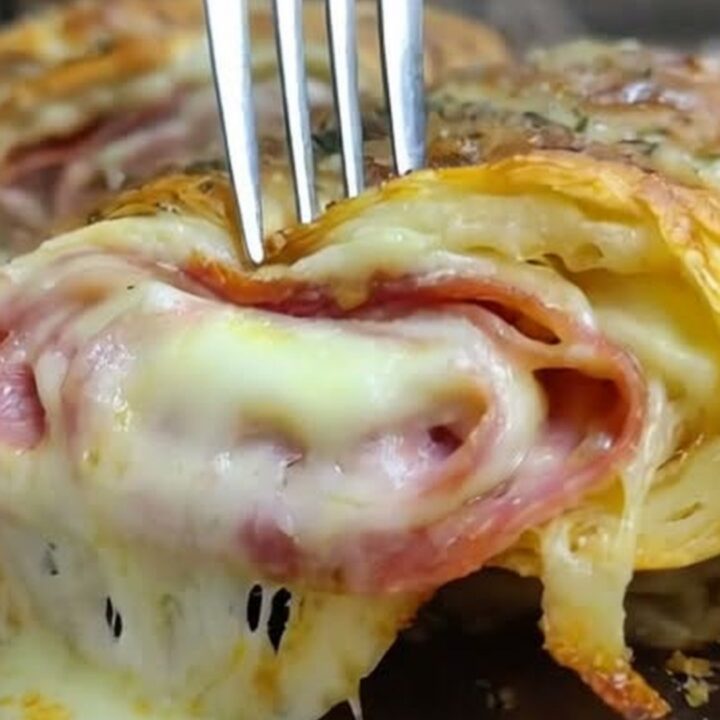 A warm, sliced homemade Italian stromboli on a wooden board, showcasing layers of meats and melted cheese.