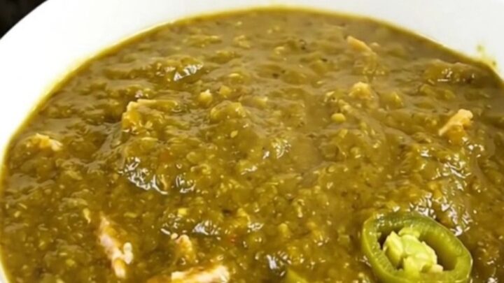 A steaming bowl of green chile ground turkey chili in a white ceramic bowl.