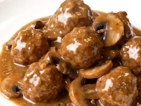 A top-down view of slow cooker turkey meatball stroganoff in a black ceramic insert.