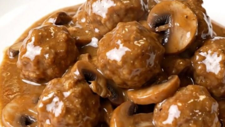 A top-down view of slow cooker turkey meatball stroganoff in a black ceramic insert.