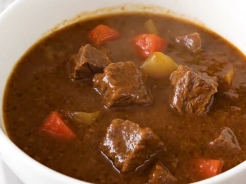A hearty bowl of slow cooker Tuscan herb beef stew with tender beef and carrots in a rich tomato sauce.
