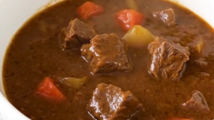 A hearty bowl of slow cooker Tuscan herb beef stew with tender beef and carrots in a rich tomato sauce.