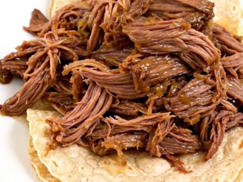 Slow cooker filled with tender, juicy barbacoa beef ready to be shredded.