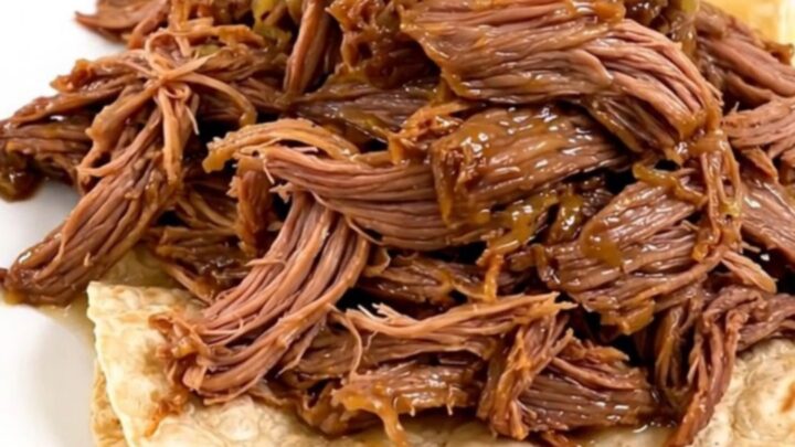 Slow cooker filled with tender, juicy barbacoa beef ready to be shredded.