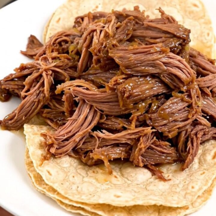 Slow cooker filled with tender, juicy barbacoa beef ready to be shredded.
