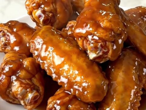 A plate of glossy mango habanero chicken wings with a sticky glaze.