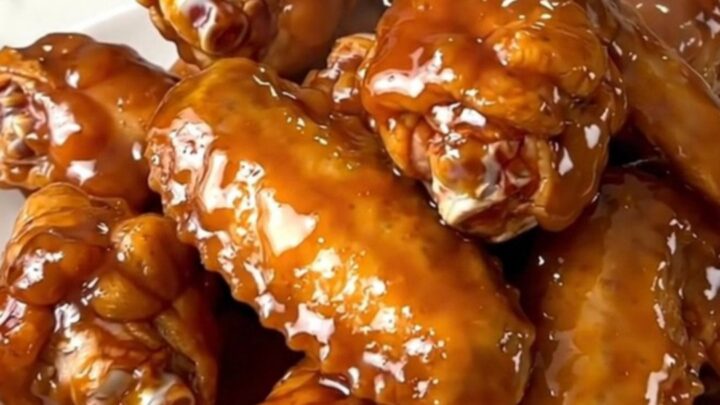 A plate of glossy mango habanero chicken wings with a sticky glaze.