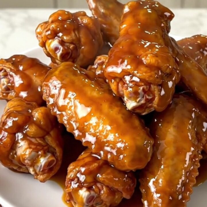 A plate of glossy mango habanero chicken wings with a sticky glaze.