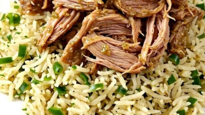 A close-up of tender, shredded salsa verde pork chops served over cilantro lime rice on a white plate.